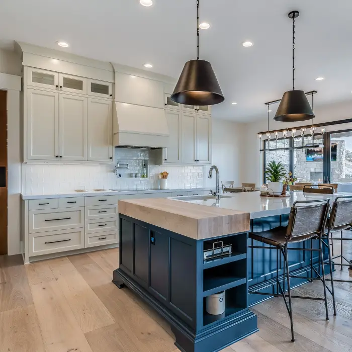 A modern kitchen with sleek design features soft natural lighting, highlighting the spacious layout that blends functionality with style. The island stands as a centerpiece, inviting culinary creativity and warm gatherings in this contemporary space.