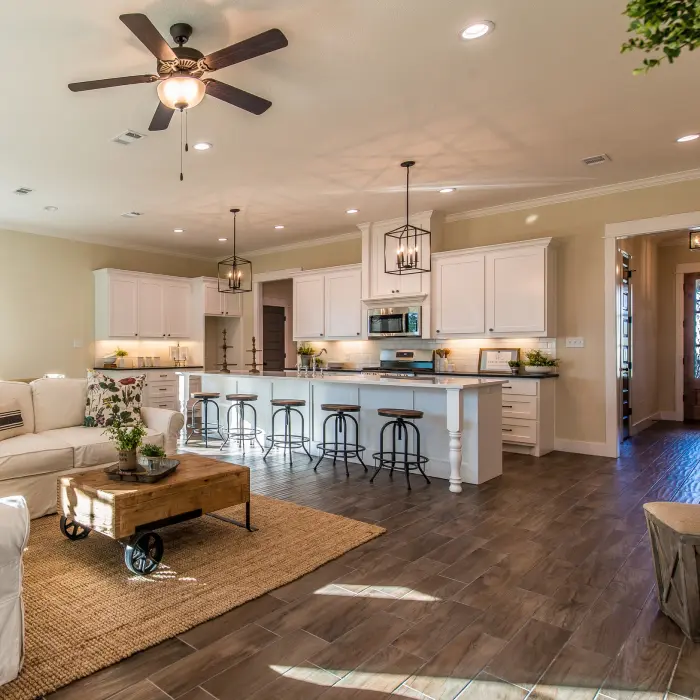 A cozy living room invites relaxation, featuring plush couches adorned with vibrant floral pillows. T